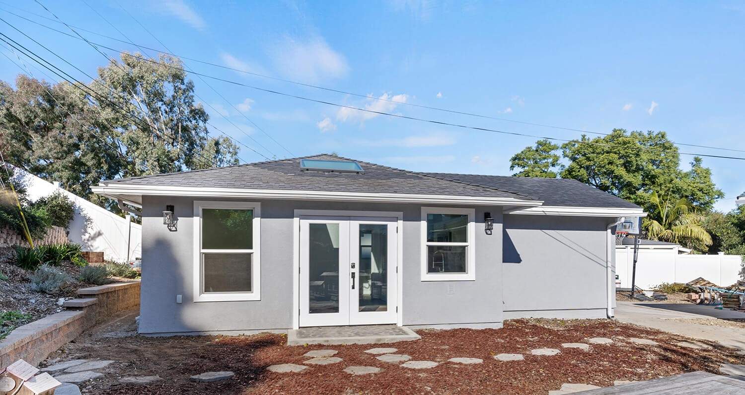 Hillstar-built ADU rear elevation with French doors and skylight — completed project