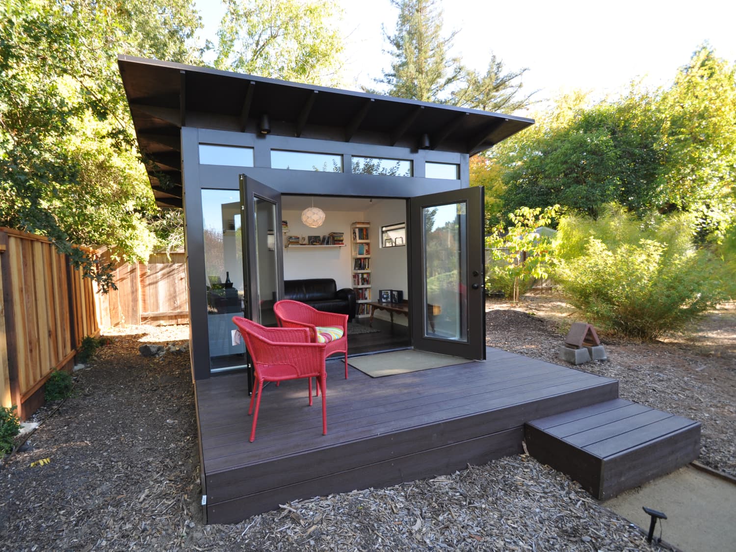 Dark-clad shed-roof Hillstar ADU with open French doors and deck seating — completed project