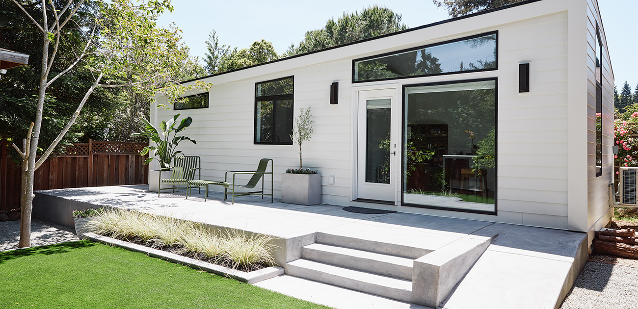 White contemporary Hillstar-built ADU with concrete deck and garden — completed project