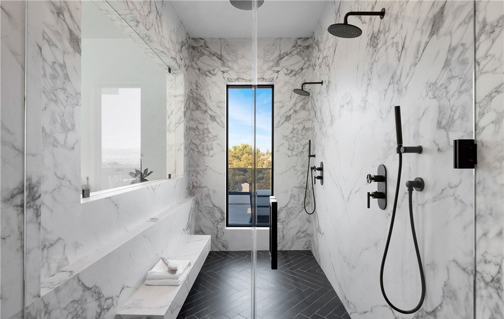 Marble walk-in shower with dual rain heads by Hillstar Construction