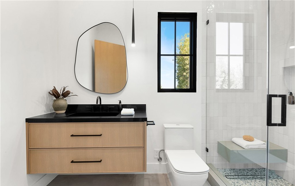 Custom bathroom vanity detail with stone countertop and integrated lighting by Hillstar Construction