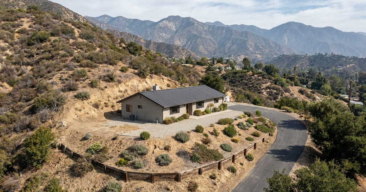A hillside home in the La Crescenta foothills with a fire-resistant roof and cleared defensible space along a brush-covered slope.