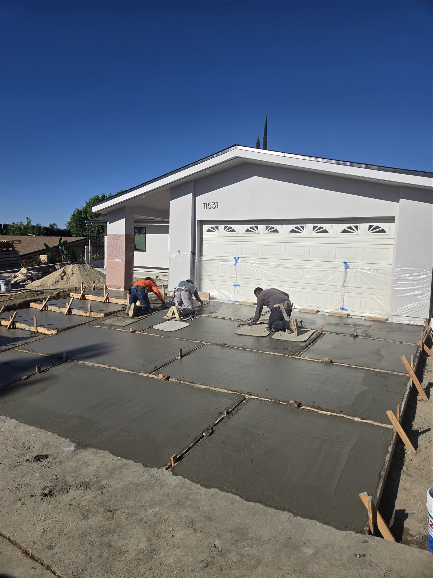 Concrete crew pouring and finishing a driveway by Hillstar Construction in Los Angeles