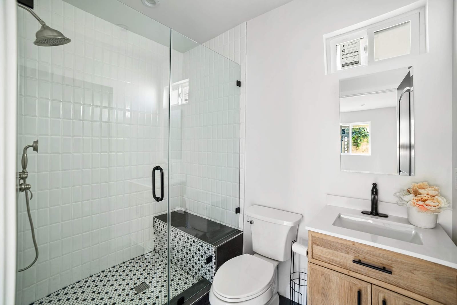 Finished ADU bathroom by Hillstar Construction Inc with white tile shower and wood vanity