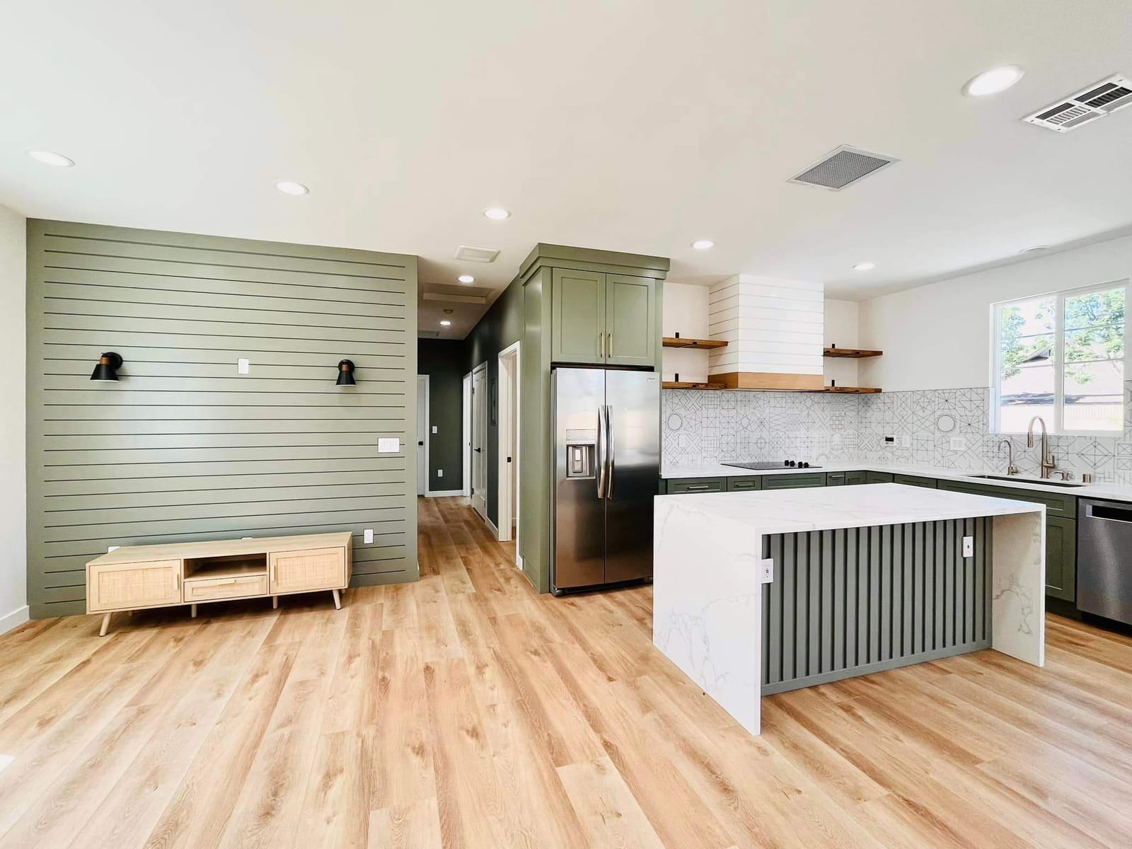 Finished ADU interior by Hillstar Construction Inc with green cabinets and open living area