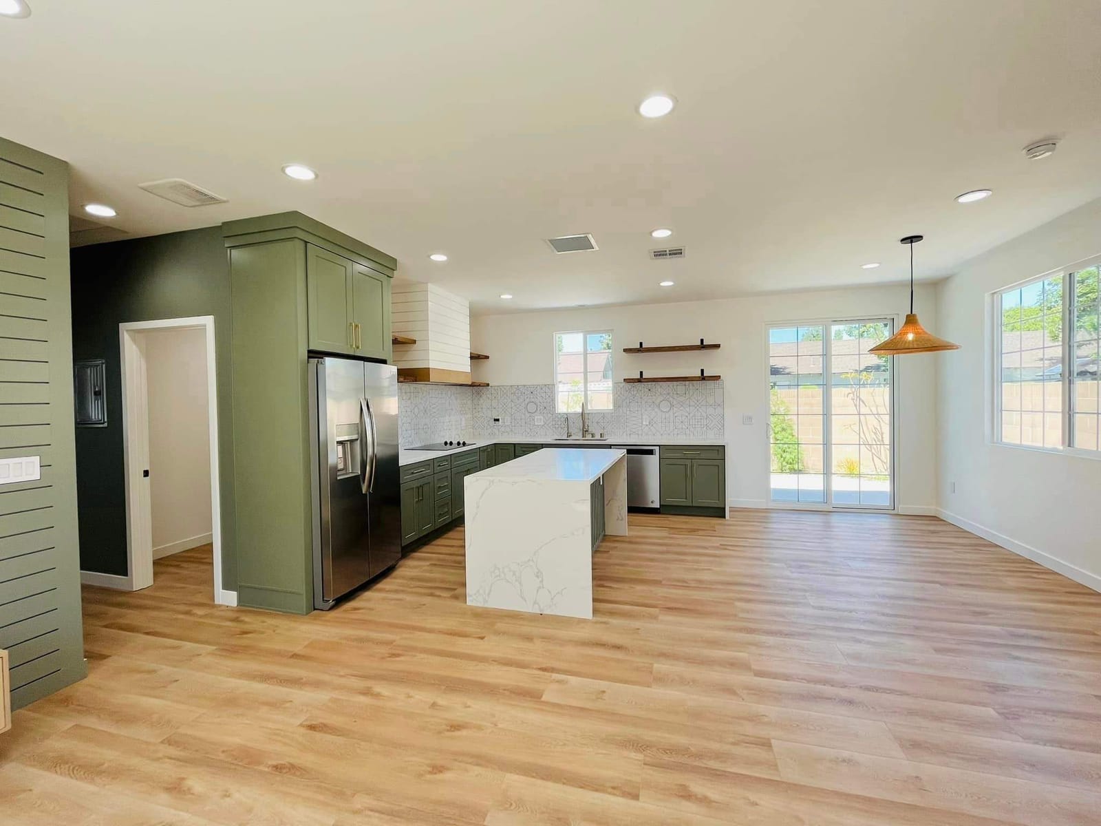Finished ADU interior by Hillstar Construction Inc with green cabinets, island and living area