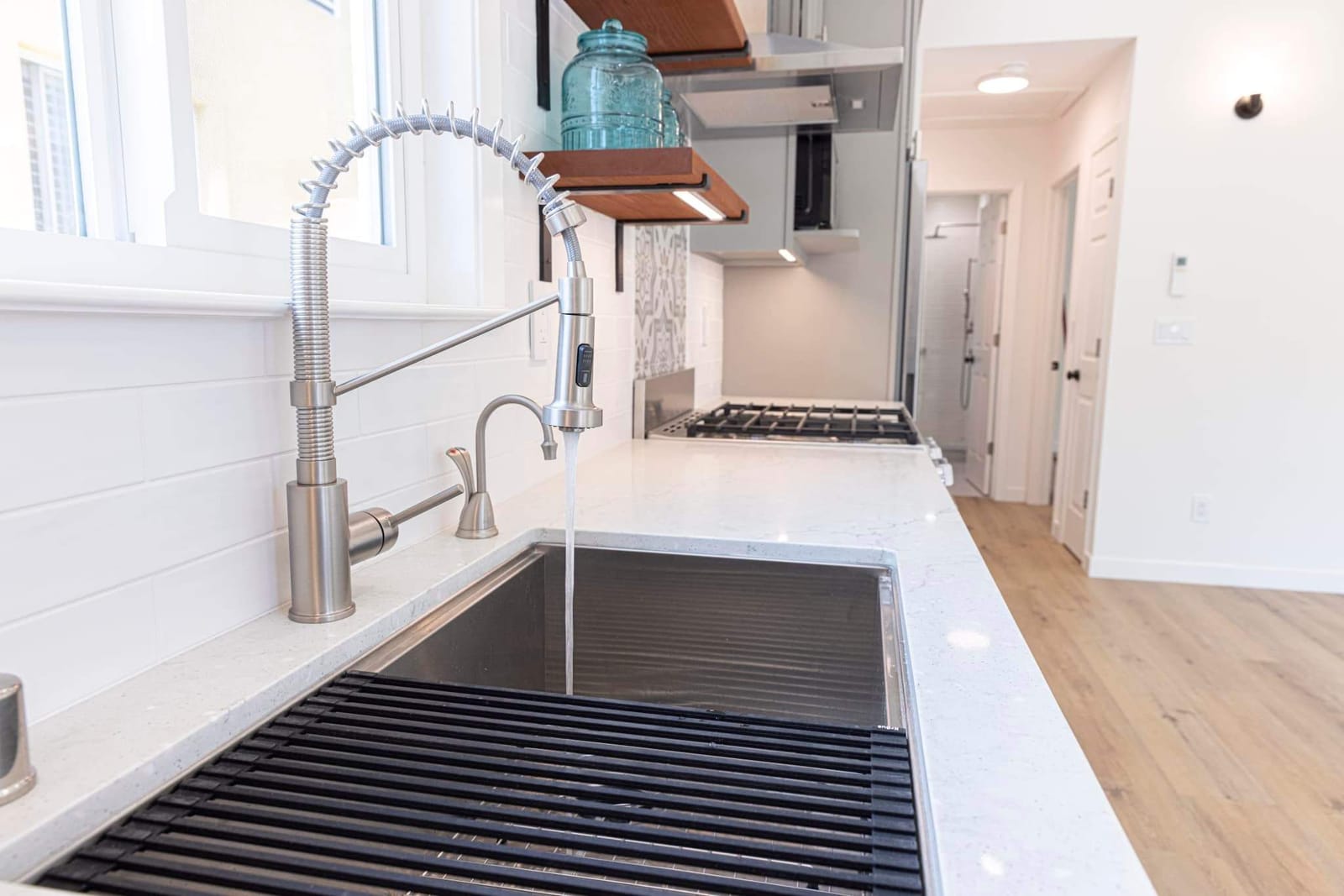 Finished ADU kitchen by Hillstar Construction Inc with window over the sink and open shelving