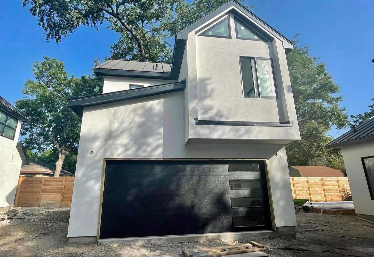 Completed two-story modern unit by Hillstar Construction Inc with garage bay and metal roof
