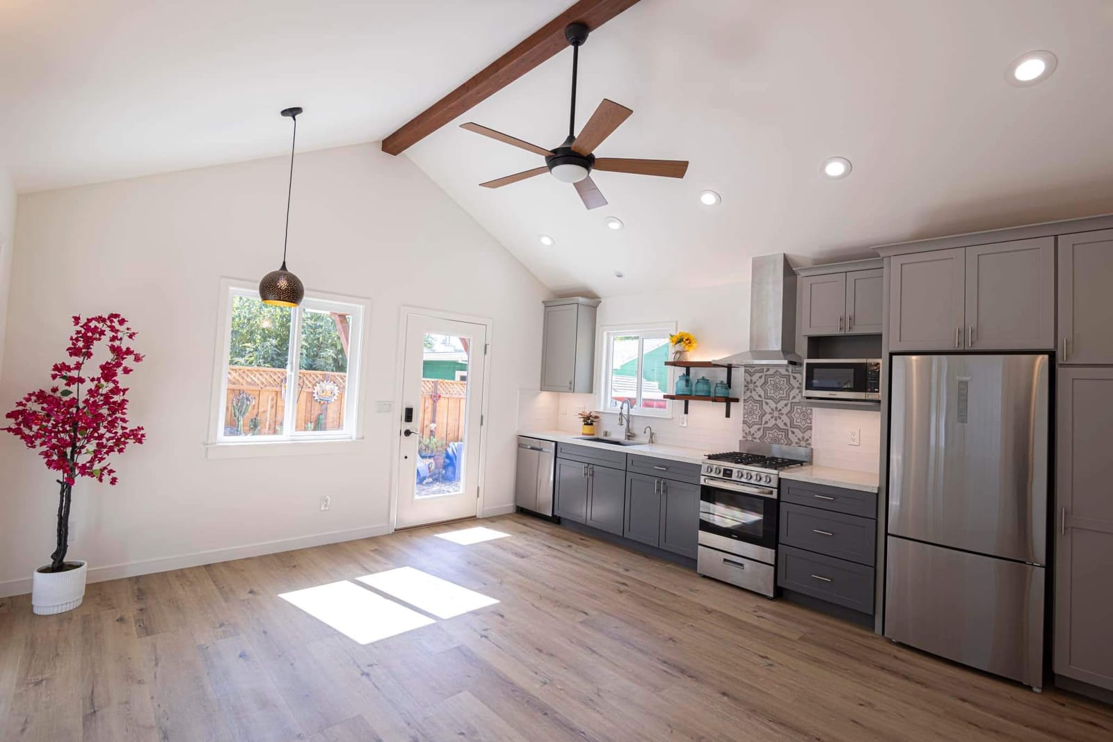 Finished ADU interior by Hillstar Construction Inc with vaulted ceiling, ceiling fan and grey kitchen